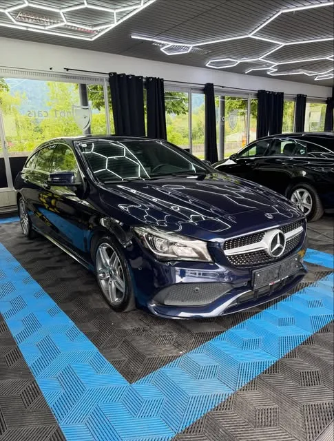 Dunkelblaue Limousine nach der Komplettaufbereitung in der Halle unter den Hexagon-Leuchten